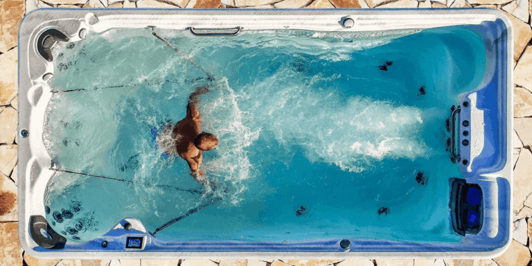 Top-down view of a man relaxing in a swim spa, enjoying the therapeutic water